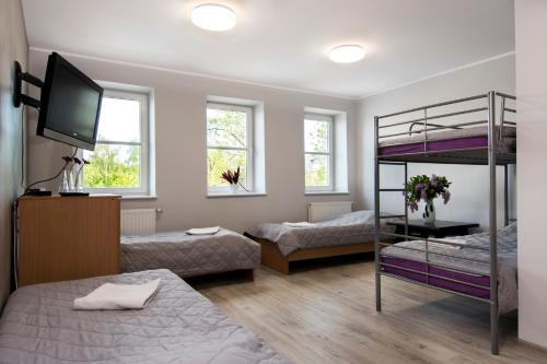 a bedroom with two bunk beds and a flat screen tv at Western Hills in Gdańsk