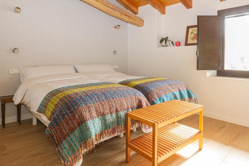 a bedroom with a bed and a wooden table at Mokorroko Borda Hostal Rural in Echalecu