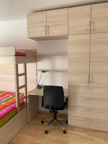 a bedroom with bunk beds and a desk and a chair at Apartment Lesnina in Kranjska Gora