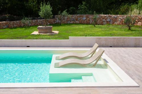 una silla de plástico sentada junto a una piscina en Villa Green Pearl, en Gostinjac