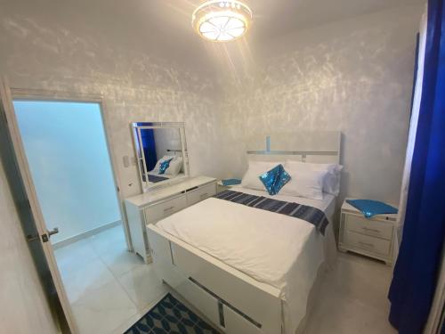 Un dormitorio pequeño con una cama y un espejo. en 7DR Apt in Prime Location Near Monumental Area, en Santiago de los Caballeros