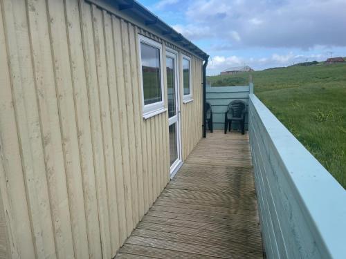 a boardwalk leading to the side of a tiny house at Morvin Self-Catering in Finstown
