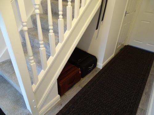 a stair case with a suitcase next to the stairs at Stony Apartment House in Doncaster