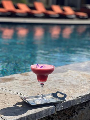 a drink in a martini glass next to a swimming pool at Château de Courban and Spa Nuxe in Courban