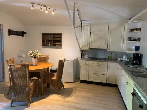 eine Küche mit einem Tisch und Stühlen sowie eine Küche mit weißen Schränken in der Unterkunft Appartement L Eiffel in Coulonges