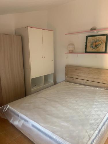 a small bedroom with a bed and a cabinet at Casa Vacanze Sibillini in Ceretana