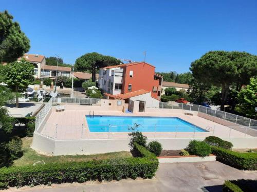 - une vue sur la piscine en face d'une maison dans l'établissement Charmant T2 cabine mezzanine, piscine, parking, proche plage et centre - Saint-Cyprien - FR-1-225D-151, à Saint-Cyprien