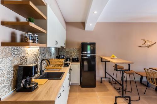 a kitchen with a black refrigerator and a table at AGNONTAS LUXURY VILLAS in Agnontas