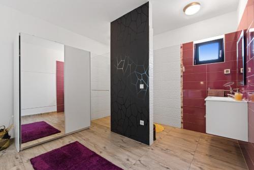 een badkamer met een schuifdeur en paarse tapijten bij Villa Leandra in Novigrad Istria