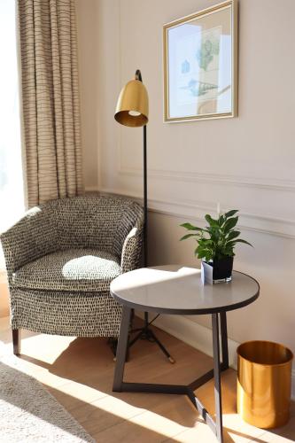 a living room with a chair and a table at Grand Hotel Seeschlösschen Sea Retreat & SPA in Timmendorfer Strand