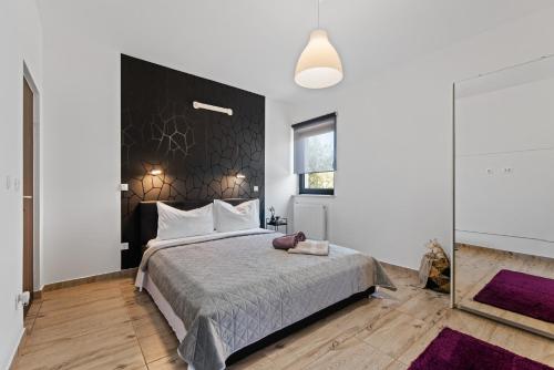 een slaapkamer met een groot bed met een zwart hoofdeinde bij Villa Leandra in Novigrad Istria