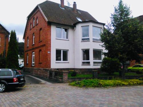 a house with a car parked in front of it at Haus an der Weser - 24/7 Check-In in Heinsen