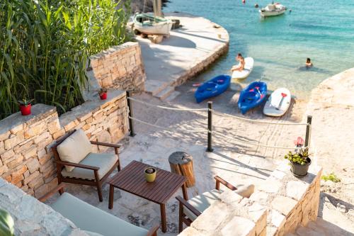 een terras met stoelen en een tafel en het water bij Orsula's Beach House in Vela Luka