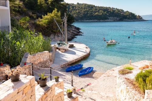 a beach with boats and people in the water at Orsula's Beach House in Vela Luka