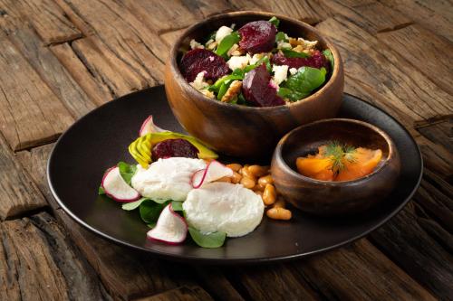 a black plate with a salad and bowls of food at ABC Entertainment Resort in Angeles