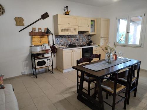 een keuken met een tafel en stoelen in een kamer bij Villa Ciù Pino in Alghero