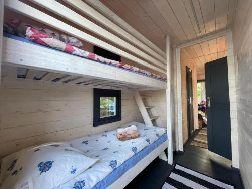 a bedroom with a bunk bed in a log cabin at AQUA Bērzgale in Bērzgale