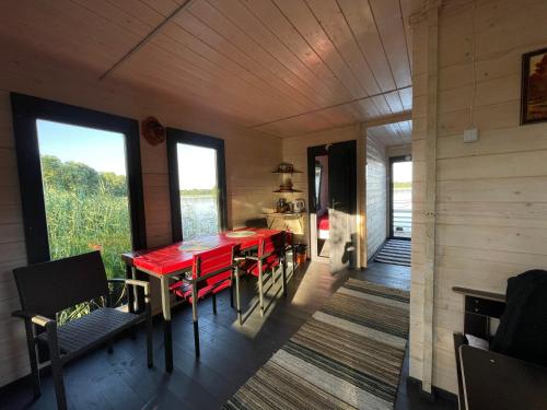 a dining room with a red table and chairs at AQUA Bērzgale in Bērzgale