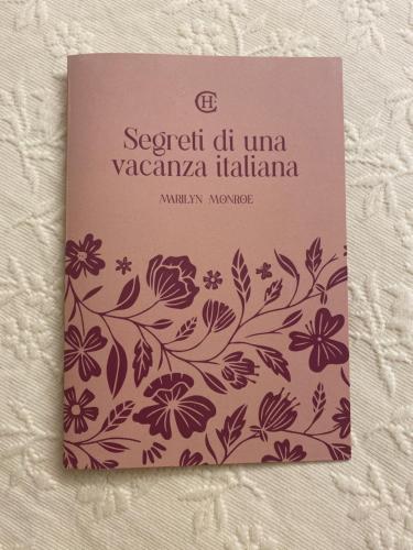 a book with a picture of flowers on it at Christy House in Vignale