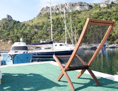una silla de madera sentada en la cubierta de un barco en House boat V al Poetto 2 pax piu' 1, en Poetto