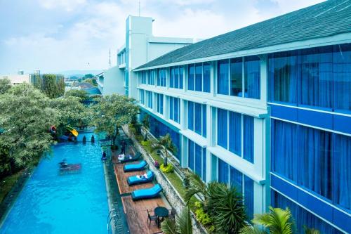 Emersia Hotel and Resort في بندر لامبونغ: فندق بمسبح بجانب مبنى