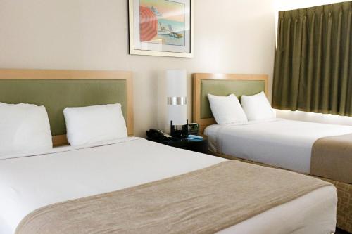 a hotel room with two beds and a window at Beach Place Hotel in Miami Beach