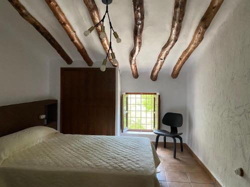a bedroom with a bed and a chair and a window at Casas Mulero Y Pastor in Férez