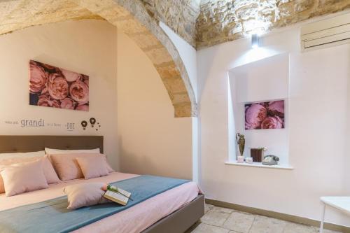 a bedroom with a bed with pink and blue sheets at Porto di Mare Apartment near the sea in Molfetta