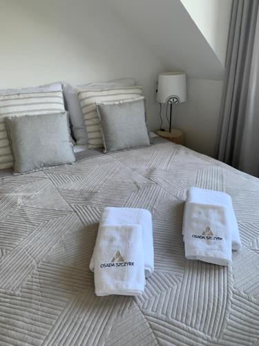 a bed with two towels on top of it at Osada Szczyrk - prywatna sauna&jacuzzi in Szczyrk