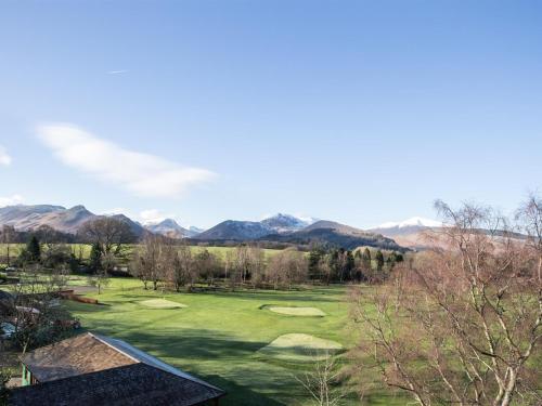 a view of a golf course with mountains in the background at LakeSide House in Keswick