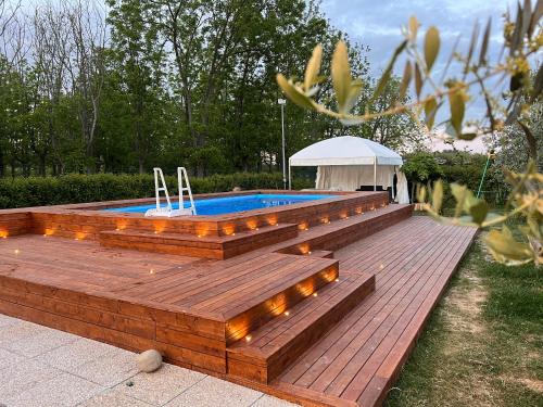 a swimming pool with a wooden deck with lights at Alpaca Village - Angolo di Paradiso in Colli del Tronto