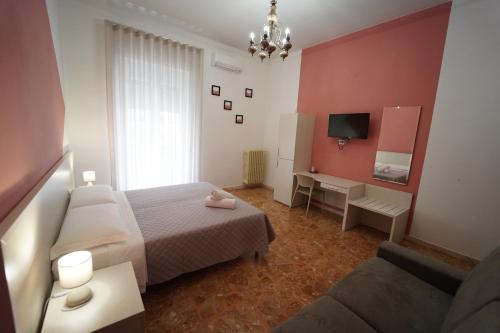 1 dormitorio con 1 cama, TV y sofá en Residence I Due Fratelli, en Matera