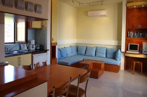 a living room with a blue couch and a kitchen at Stefanakis Villas - Car Included in Livadia