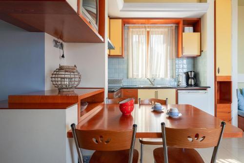 une petite cuisine avec une table et des chaises en bois dans l'établissement Stefanakis Villas - Car Included, à Livadia