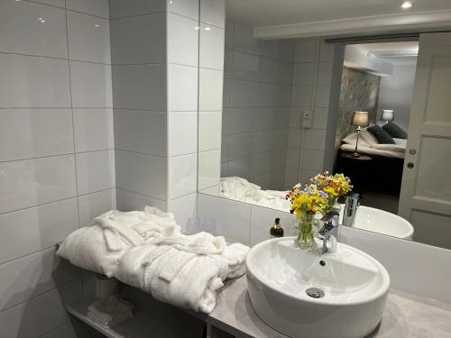 a white bathroom with a sink and a mirror at Hotell Bele in Trollhättan