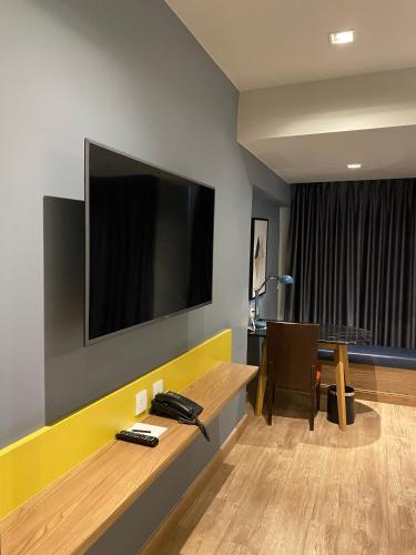 a room with a desk with a television on a wall at The Quarter Ladprao by UHG in Bangkok