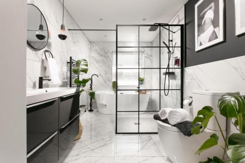 a bathroom with a tub and a toilet and a sink at The LUXE - Premium Georgian Central Plymouth House - Sleeps 8 - Habita Property in Plymouth