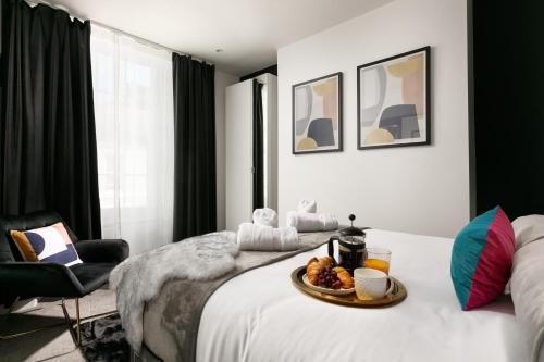 a room with a bed with a tray of food on it at The LUXE - Premium Georgian Central Plymouth House - Sleeps 8 - Habita Property in Plymouth