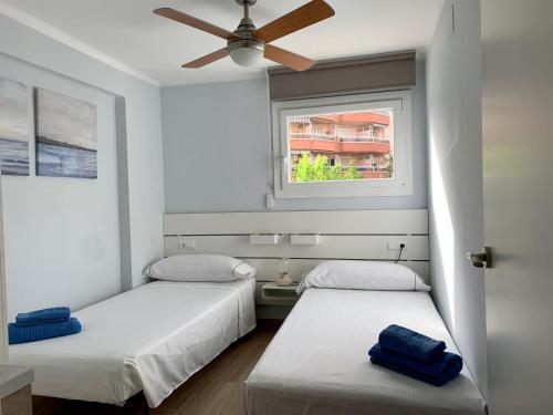 2 bedden in een kamer met een plafondventilator bij Be-Cool Salou pool center in Salou