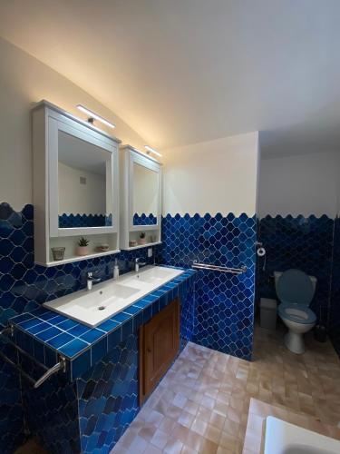 a blue tiled bathroom with a sink and a toilet at Villa Vence in Vence