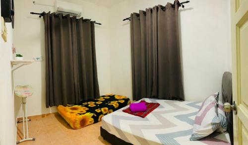 1 dormitorio con 1 cama con cortinas negras en Nurul Amin Guest House Pantai Cahaya Bulan Kota Bharu en Kota Bharu