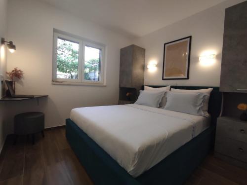 a bedroom with a large bed and a window at Ferma in Makarska