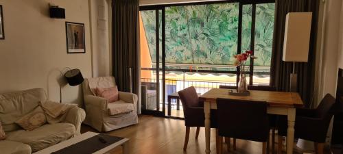 a living room with a table and chairs and a window at Old town - Beach apartment in Benidorm