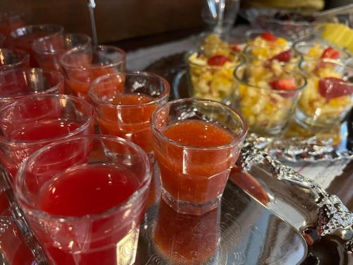 a group of glasses filled with red liquid next to a tray of food at Hotell Bele in Trollhättan