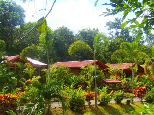 a house with a garden of flowers and trees at Hotel Heliconias Nature Inn & Hot Springs in Fortuna