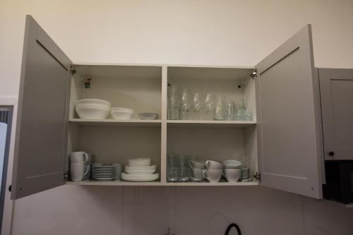 a cabinet filled with plates and cups and dishes at P&M Apartament by Rentoom in Toruń