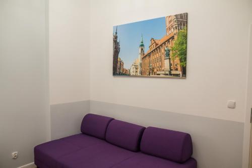 a purple couch in a room with a painting on the wall at P&M Apartament by Rentoom in Toruń