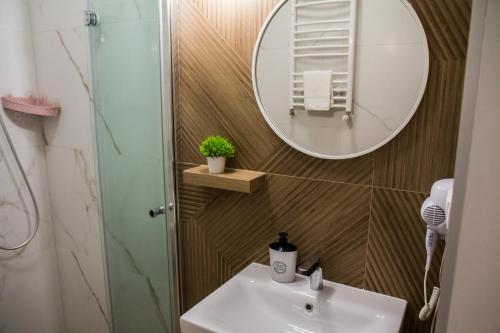 a bathroom with a sink and a mirror at P&M Apartament by Rentoom in Toruń