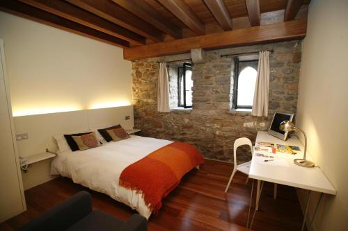 1 dormitorio con 1 cama y escritorio con lámpara en Larramendi Torrea, en Azcoitia