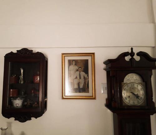 two clocks on a wall next to a picture of a man at Casa Zaida Hostal Vintage in Ríohacha